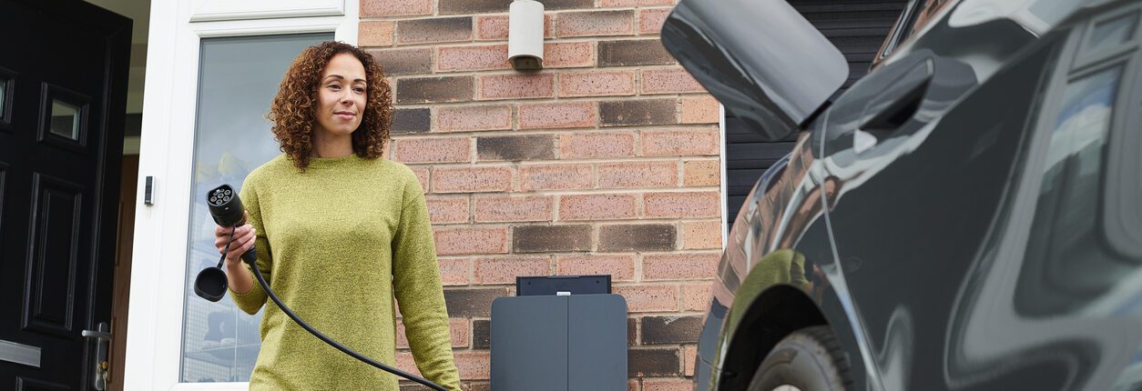 Propriétaire rechargeant sa voiture électrique dans l'allée
