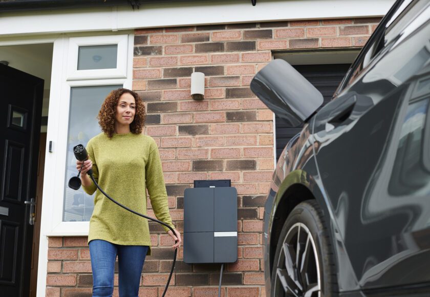 Propriétaire rechargeant sa voiture électrique dans l'allée