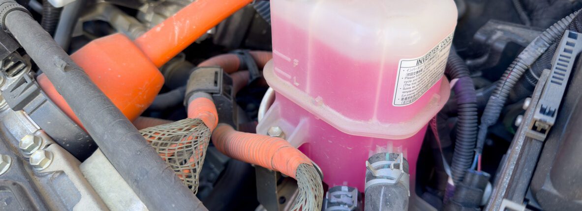Bouteille de liquide de refroidissement dans le compartiment moteur de la voiture, fabriquée en plastique translucide et résistant.