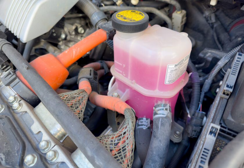 Bouteille de liquide de refroidissement dans le compartiment moteur de la voiture, fabriquée en plastique translucide et résistant.