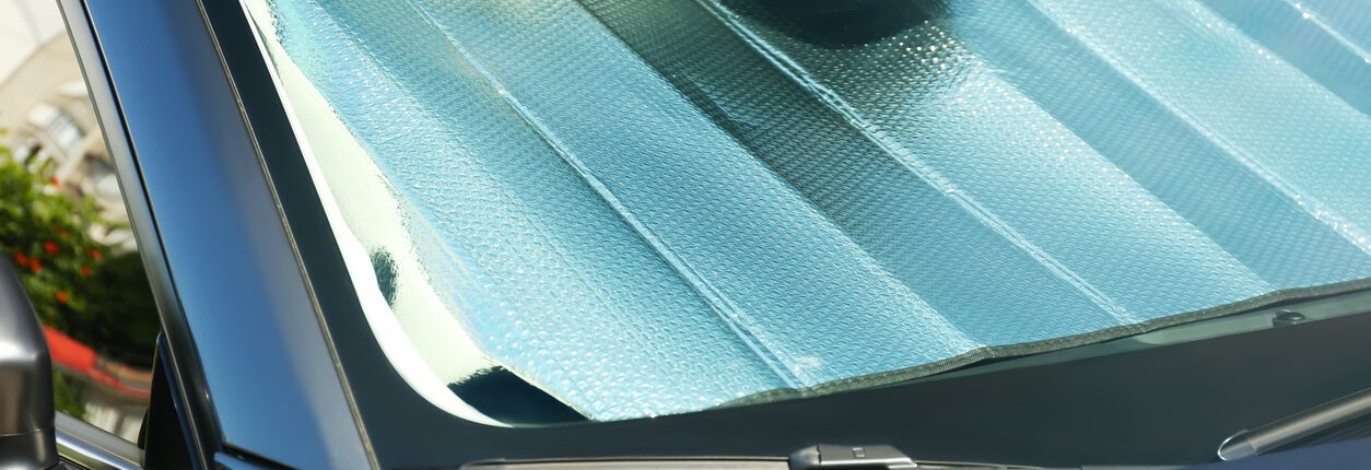 Pare-soleil sous le pare-brise à l’intérieur de la voiture, en gros plan. Protection contre la chaleur.