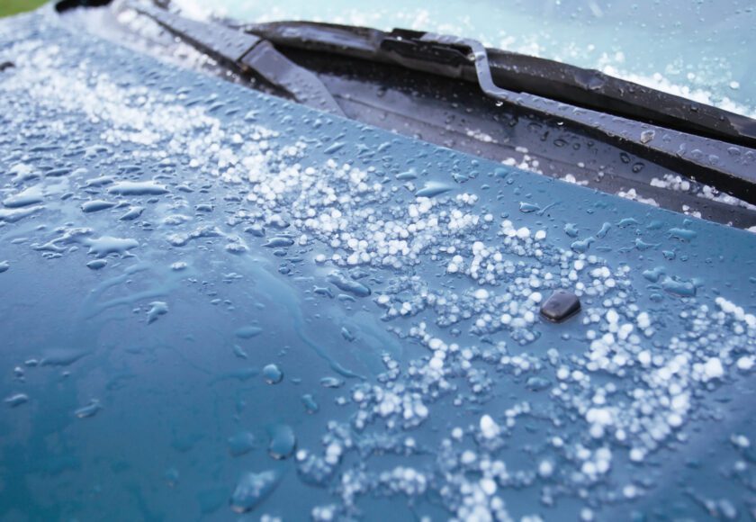 Juste après une tempête, vue abstraite des grêlons commençant à fondre sur le capot de cette voiture.