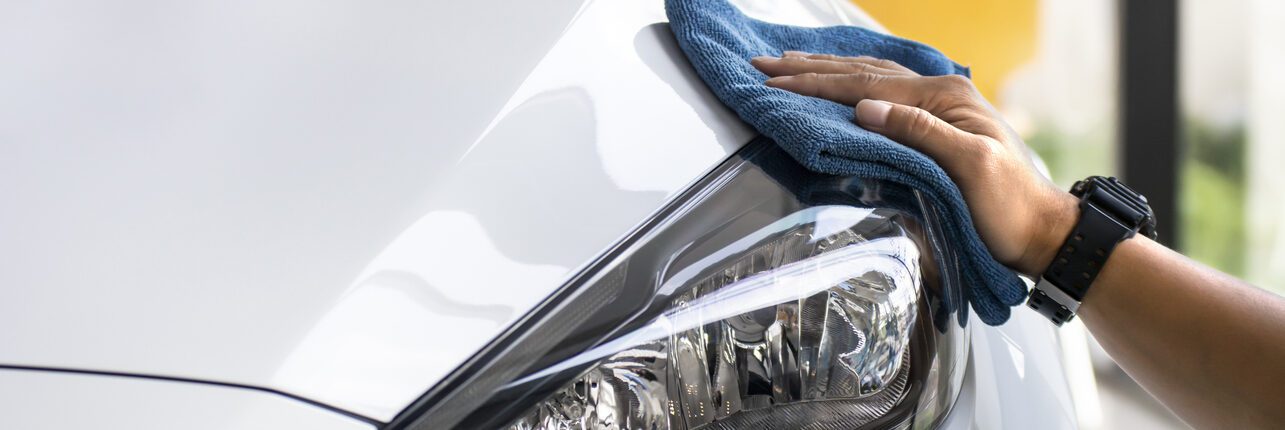 Une personne qui nettoie son phare optique de voiture