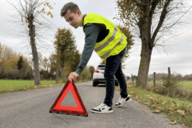 Un homme venant d'avoir un accident, pose son triangle de présignalisation vêtit de son gilet jaune de sécurité