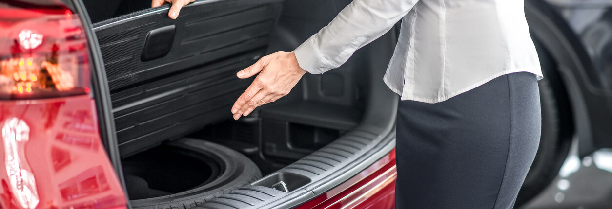 femme qui montre sa solution pour éviter de rester bloqué sur le bas côté de la route : son kit roue de secours Norauto
