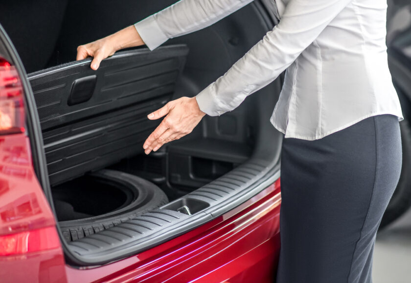 femme qui montre sa solution pour éviter de rester bloqué sur le bas côté de la route : son kit roue de secours Norauto