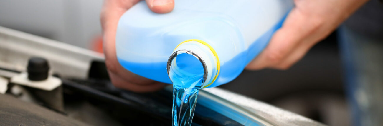 Un homme injectant de l'anti cristallisant AdBlue dans son réservoir AdBlue.