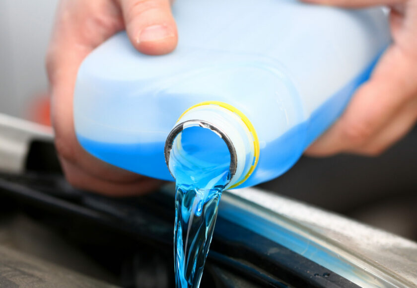 Un homme injectant de l'anti cristallisant AdBlue dans son réservoir AdBlue.