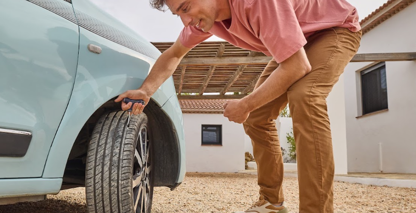 Un homme qui répare son pneu avec le kit de réparation crevaison provisoire par mèche NORAUTO 8 pièces